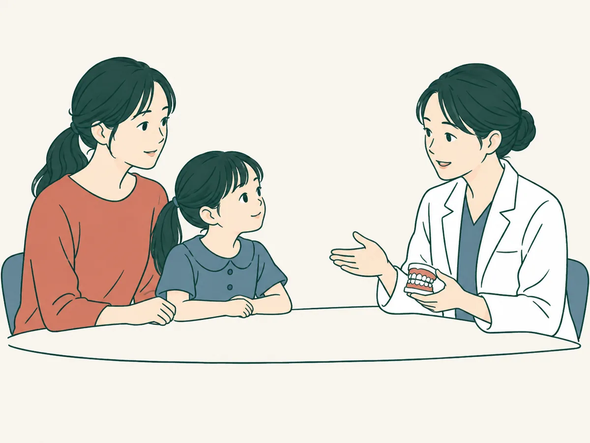 女性の歯科医師が歯の模型を見せながら親子に説明しているイラスト